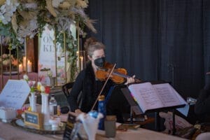 a woman wearing a face mask playing a violin