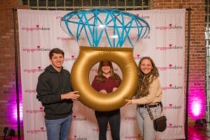 3 People are taking photo with ring shape ballon